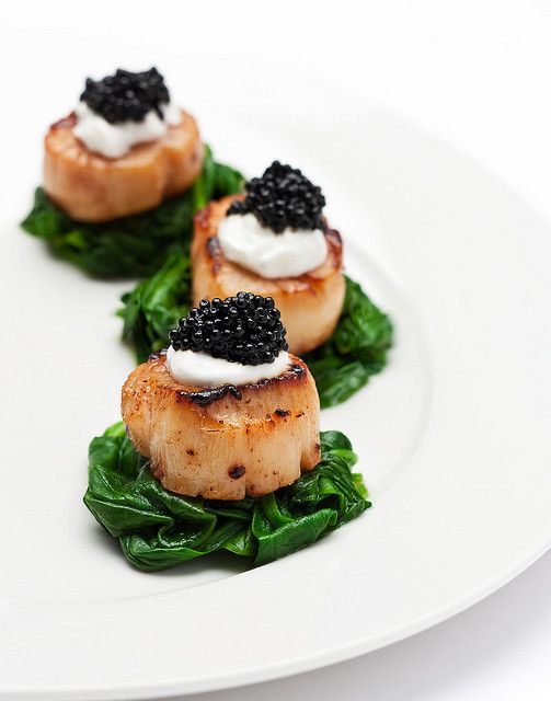assiette de coquilles st jacques avec au dessus du fromage frais et quelques grains de caviar benezet caviar